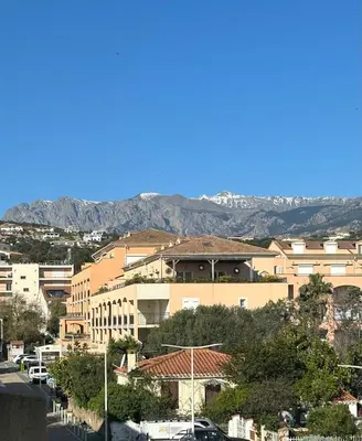 a view of a city with mountains in the background at Charmant T2 sur le Port de Plaisance de Solenzara in Sari Solenzara