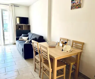 a living room with a table and a blue couch at Charmant T2 sur le Port de Plaisance de Solenzara in Sari Solenzara