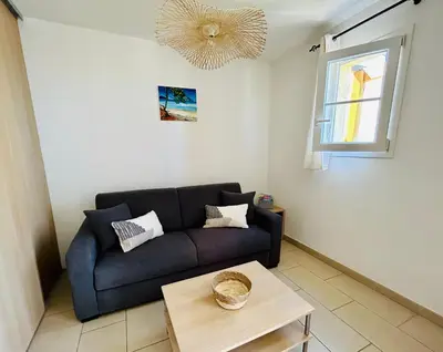 a living room with a couch and a table at Charmant T2 sur le Port de Plaisance de Solenzara in Sari Solenzara