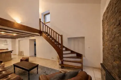 a living room with a staircase and a couch at Appartement charmant - Entre campagne et ville in Corte