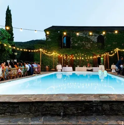 a swimming pool with lights and people sitting at Appartement charmant - Entre campagne et ville in Corte