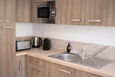 a kitchen with a sink and a microwave at Résidence A Stella in Piana