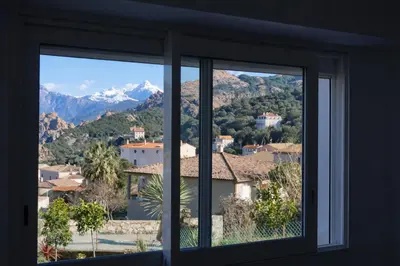 a window with a view of a city and mountains at Résidence A Stella in Piana