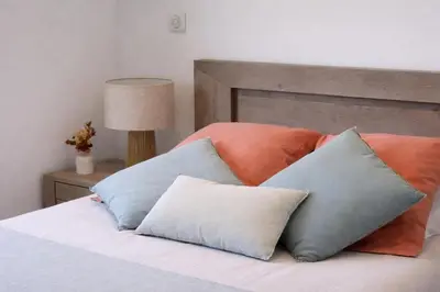 a bed with four pillows on top of it at Résidence A Stella in Piana
