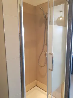 a shower with a glass door in a bathroom at Beautiful modern 4-star apartment with swimming pool and Wi-Fi in Porto-Vecchio