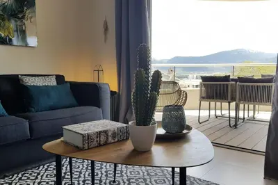 a living room with a couch and a table with a cactus at Beautiful modern 4-star apartment with swimming pool and Wi-Fi in Porto-Vecchio