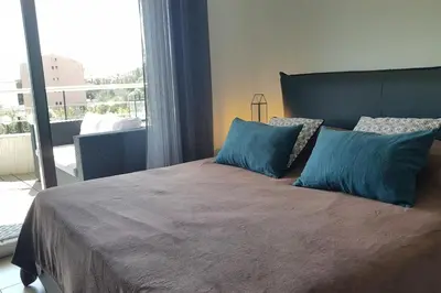 a bedroom with a large bed with blue pillows at Beautiful modern 4-star apartment with swimming pool and Wi-Fi in Porto-Vecchio