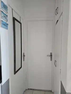 a hallway with a mirror and a door at Bas de villa 27 Pietrosella in Pietrosella