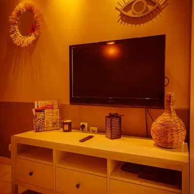 a flat screen tv on a wall above a shelf at Bas de villa 27 Pietrosella in Pietrosella