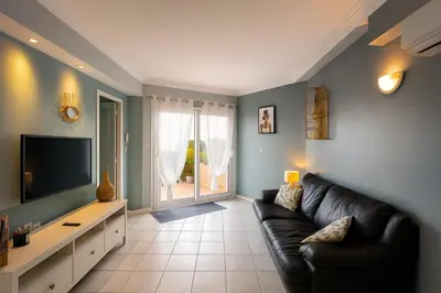 a living room with a couch and a television at Bas de villa 27 Pietrosella in Pietrosella