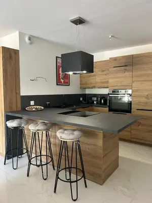 a kitchen with a island with bar stools in it at Résidence Les Jardins du Piale in Bonifacio