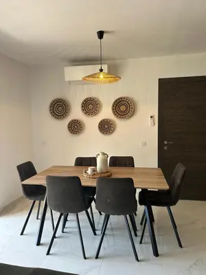 a dining room with a wooden table and chairs at Résidence Les Jardins du Piale in Bonifacio