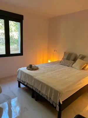 a bedroom with a large bed in a room at Résidence Les Jardins du Piale in Bonifacio