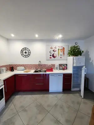 a kitchen with red cabinets and a white refrigerator at Horizon bleu in Ventiseri