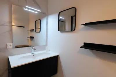 a bathroom with a sink and a mirror at L'Orizonte - T3 vue mer piscine et plage in Pianottoli-Caldarello