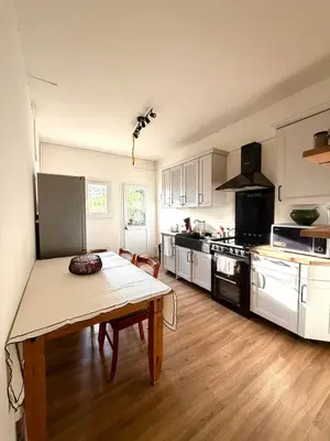 a kitchen with a wooden table and a kitchen with white cabinets at Villa San Michele 3 chambres in Linguizzetta