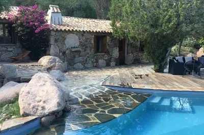 a house with a swimming pool and a stone building at Charming villa # Petra's House in Palombaggia in Porto-Vecchio