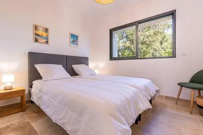 a bedroom with a large bed and a window at Villa U Capu - Piscine Privée in Lecci