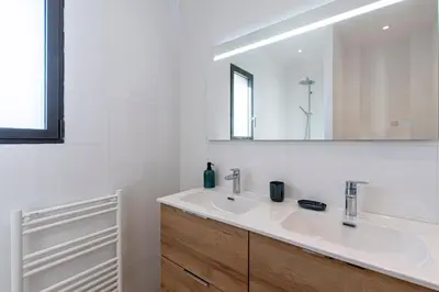 a white bathroom with a sink and a mirror at Villa U Capu - Piscine Privée in Lecci