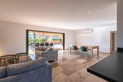 a living room with a couch and a table and chairs at Villa U Capu - Piscine Privée in Lecci