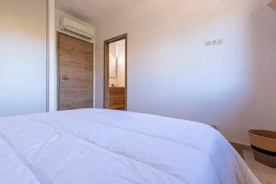 a bedroom with a white bed and a door at Villa U Capu - Piscine Privée in Lecci