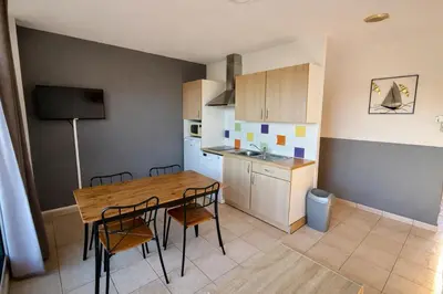 a kitchen and dining room with a wooden table and chairs at Appartement 4 personnes - Soléa 137 - Vue Mer in Serra-di-Ferro