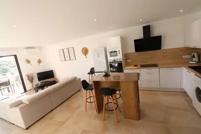 a kitchen and living room with a couch and a table at L'ÉCRIN - T2 65 m2 - Terrasse vue Mer & Maquis - Agosta plage à 200m- Parking privé in Albitreccia