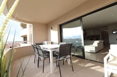 a dining room with a table and chairs on a balcony at L'ÉCRIN - T2 65 m2 - Terrasse vue Mer & Maquis - Agosta plage à 200m- Parking privé in Albitreccia