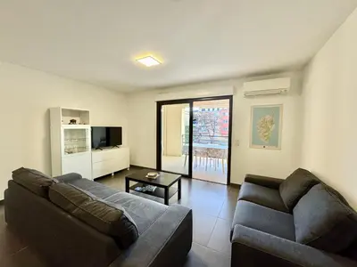a living room with a couch and a table at 2 pièces au cœur de la ville de Propriano in Propriano