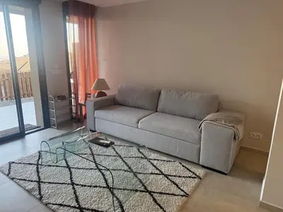 a living room with a couch and a glass table at Appartement vue mer et montagne in Olmeta-di-Tuda