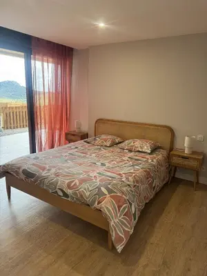 a bedroom with a bed and a large window at Appartement vue mer et montagne in Olmeta-di-Tuda