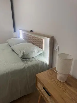 a bedroom with a bed and a table with a lamp at Appartement vue mer et montagne in Olmeta-di-Tuda