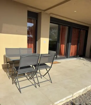 a table and chairs sitting on a patio at Appartement vue mer et montagne in Olmeta-di-Tuda
