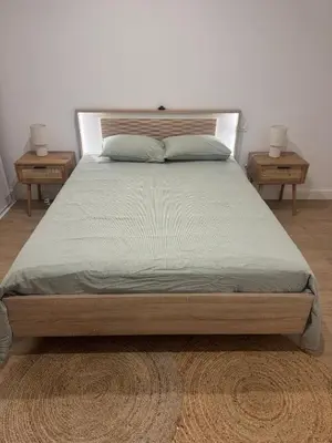 a large bed with two nightstands and two tables at Appartement vue mer et montagne in Olmeta-di-Tuda