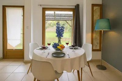a table with a bowl of fruit and wine glasses at Mini villa vue jardin dans résidence calme wifi piscine mer à pied in Serra-di-Ferro