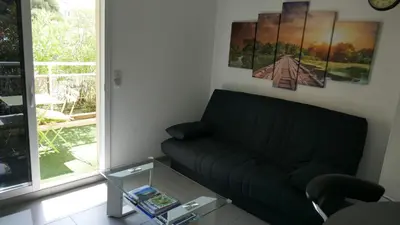a living room with a couch and a glass table at Appartement 3 étoiles près des plages d'Ajaccio in Ajaccio