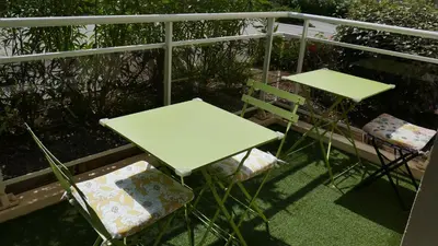 a table and two chairs on a balcony at Appartement 3 étoiles près des plages d'Ajaccio in Ajaccio