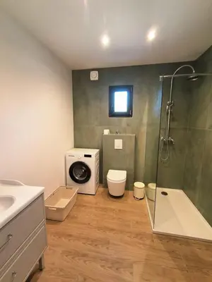 a bathroom with a shower and a washing machine at Lumineux studio entre terre et mer à 2min de la plage in Calcatoggio