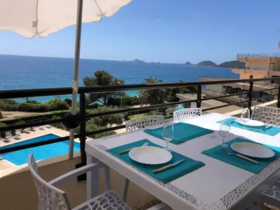 a white table with chairs and a view of the ocean at Ajaccio Sanguinaires - 3p - Terrasse - Piscine in Ajaccio