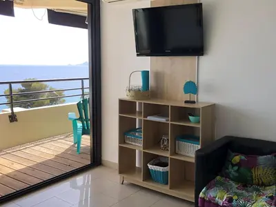 a living room with a television and a balcony at Ajaccio Sanguinaires - 3p - Terrasse - Piscine in Ajaccio