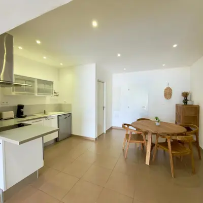 a kitchen and living room with a table and chairs at Deux pièces tout confort vue mer imprenable in Propriano