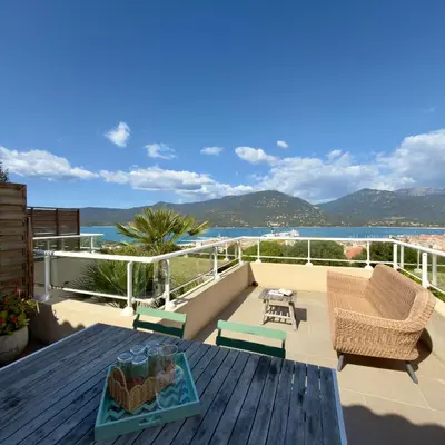 a balcony with chairs and a view of the water at Deux pièces tout confort vue mer imprenable in Propriano