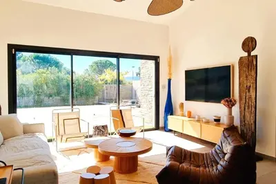 a living room with a couch and a table at Charming setting with private pool in Cala Rossa in Lecci