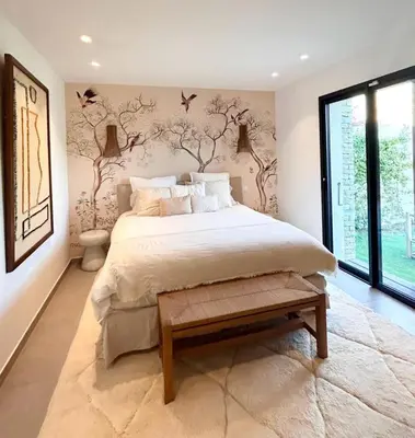 a bedroom with a large bed with birds on the wall at Charming setting with private pool in Cala Rossa in Lecci