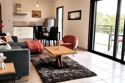 a living room with a couch and a table at Godichard Apartment in a residence for 46 people with swimming pool and in Porto-Vecchio