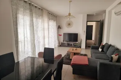 a living room with a couch and a tv at Godichard Apartment in a residence for 46 people with swimming pool and in Porto-Vecchio