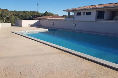 a swimming pool on the side of a house at Godichard Apartment in a residence for 46 people with swimming pool and in Porto-Vecchio