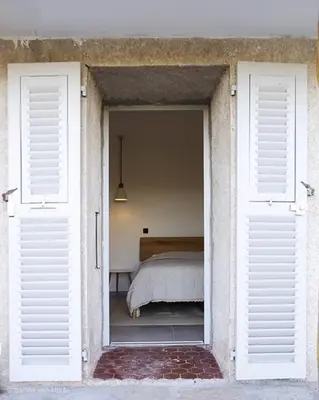 a white building with a bench and a window at Villa Golfe Favone Corsica 10P Pool Sea View in Sari Solenzara