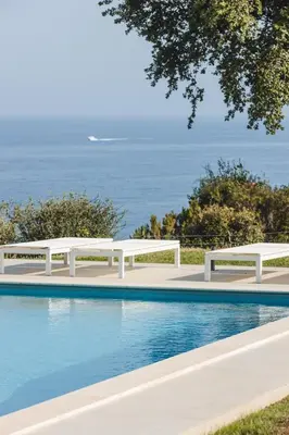 a living room with a wooden table and white chairs at Villa Golfe Favone Corsica 10P Pool Sea View in Sari Solenzara