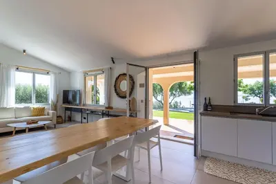 a long table with plates and wine glasses on a patio at Villa Golfe Favone Corsica 10P Pool Sea View in Sari Solenzara